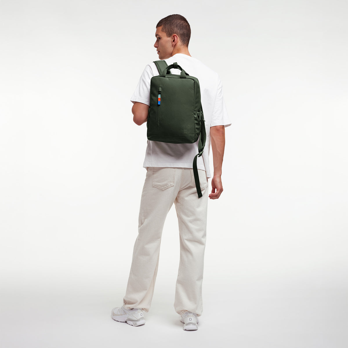 DAYPACK 2.0 Rucksack in algae (Dunkelgrün mit Graustich) von einem Mann als Rucksack auf dem Rücken getragen.
