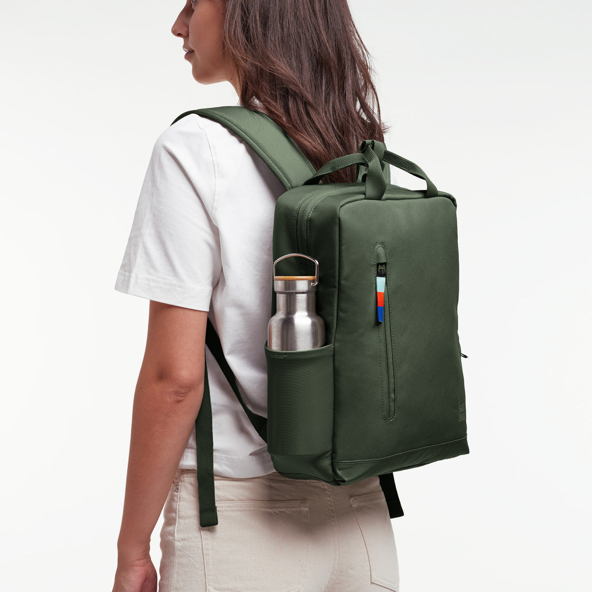 DAYPACK 2.0 Rucksack in algae (Dunkelgrün mit Graustich) von einer Frau als Rucksack auf dem Rücken getragen.