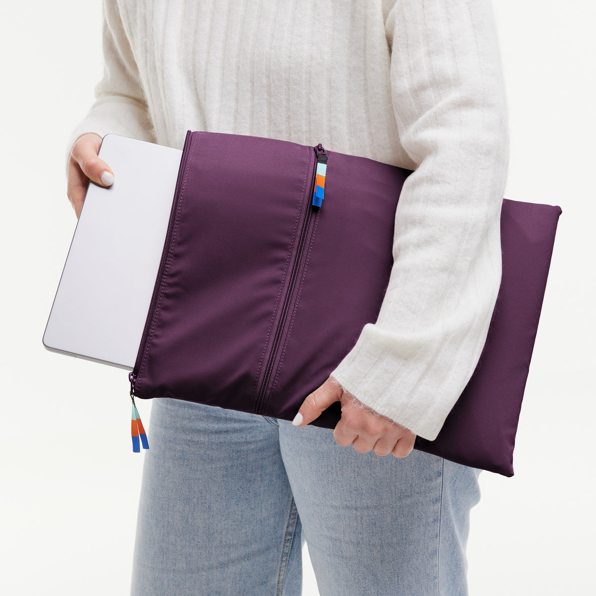 ROLLTOP Tasche in favia (warmes Dunkellila / Pflaumenfarben) von einer Frau in der Hand gehalten.