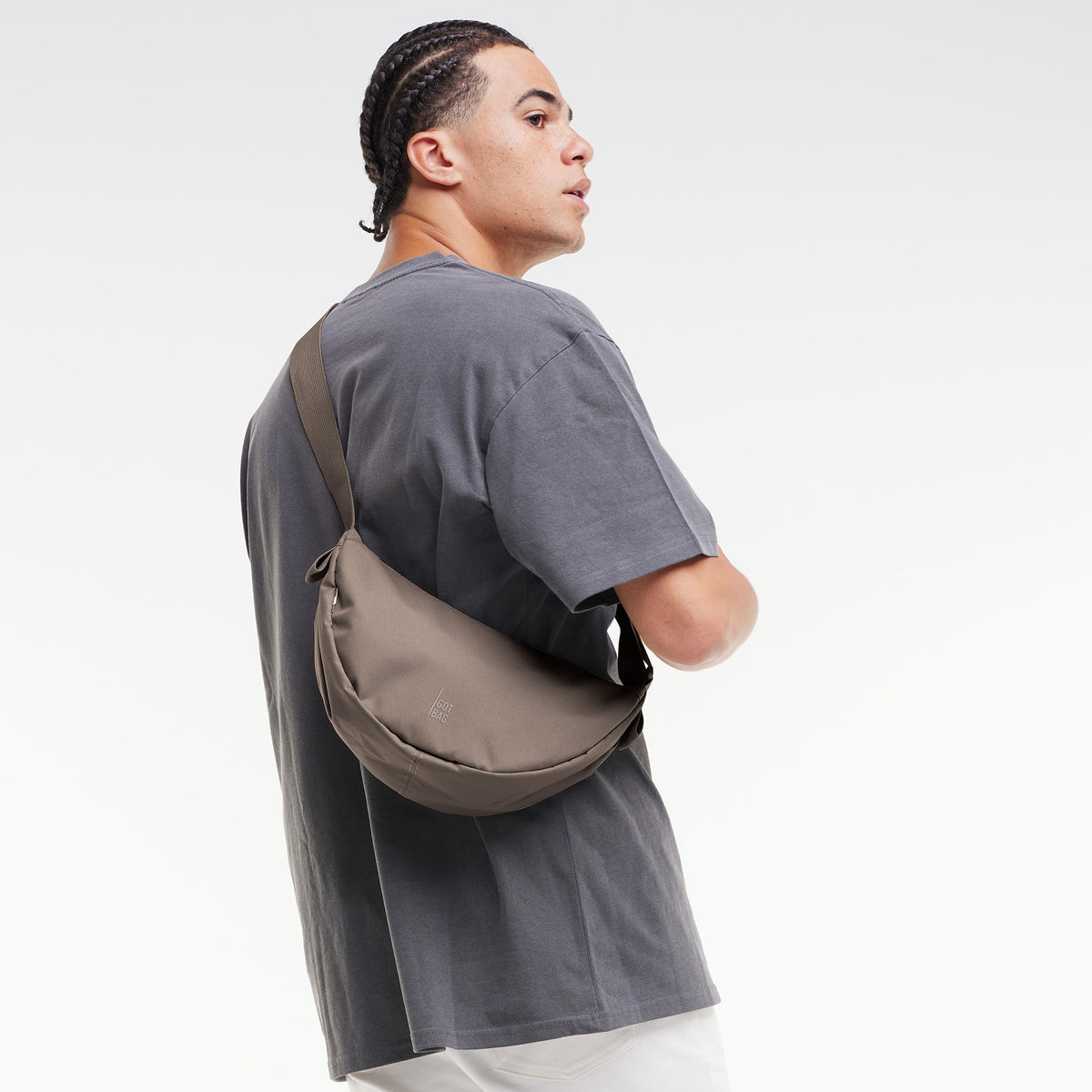MOON BAG SMALL Tasche in oyster (klassisches Taupe-Braun) von einem Mann crossbody getragen.
