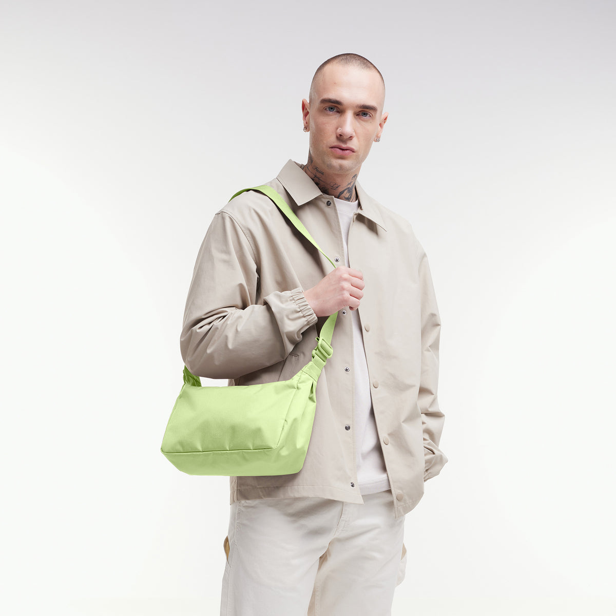 SQUARE BAG SMALL Tasche in wrasse (neonfarbenes Hellgrün) von einem Mann crossbody getragen.