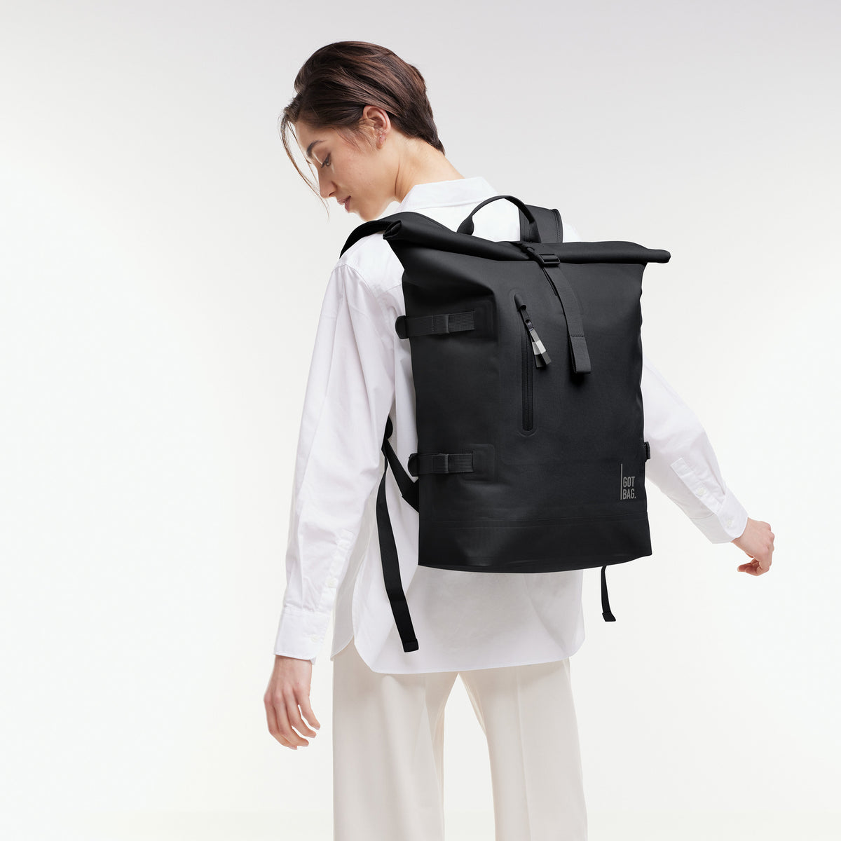ROLLTOP 2.0 Rucksack in black (Schwarz) von einer Frau als Rucksack auf dem Rücken getragen.