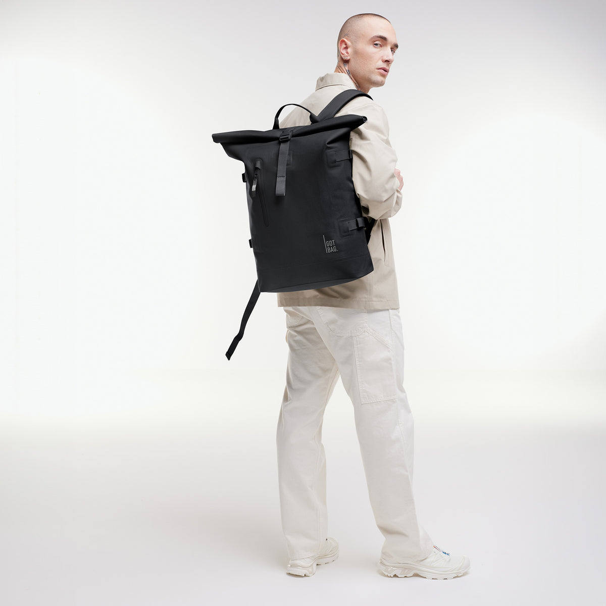 ROLLTOP 2.0 MONOCHROME EDITION Rucksack in black (Schwarz) von einem Mann als Rucksack auf dem Rücken getragen.