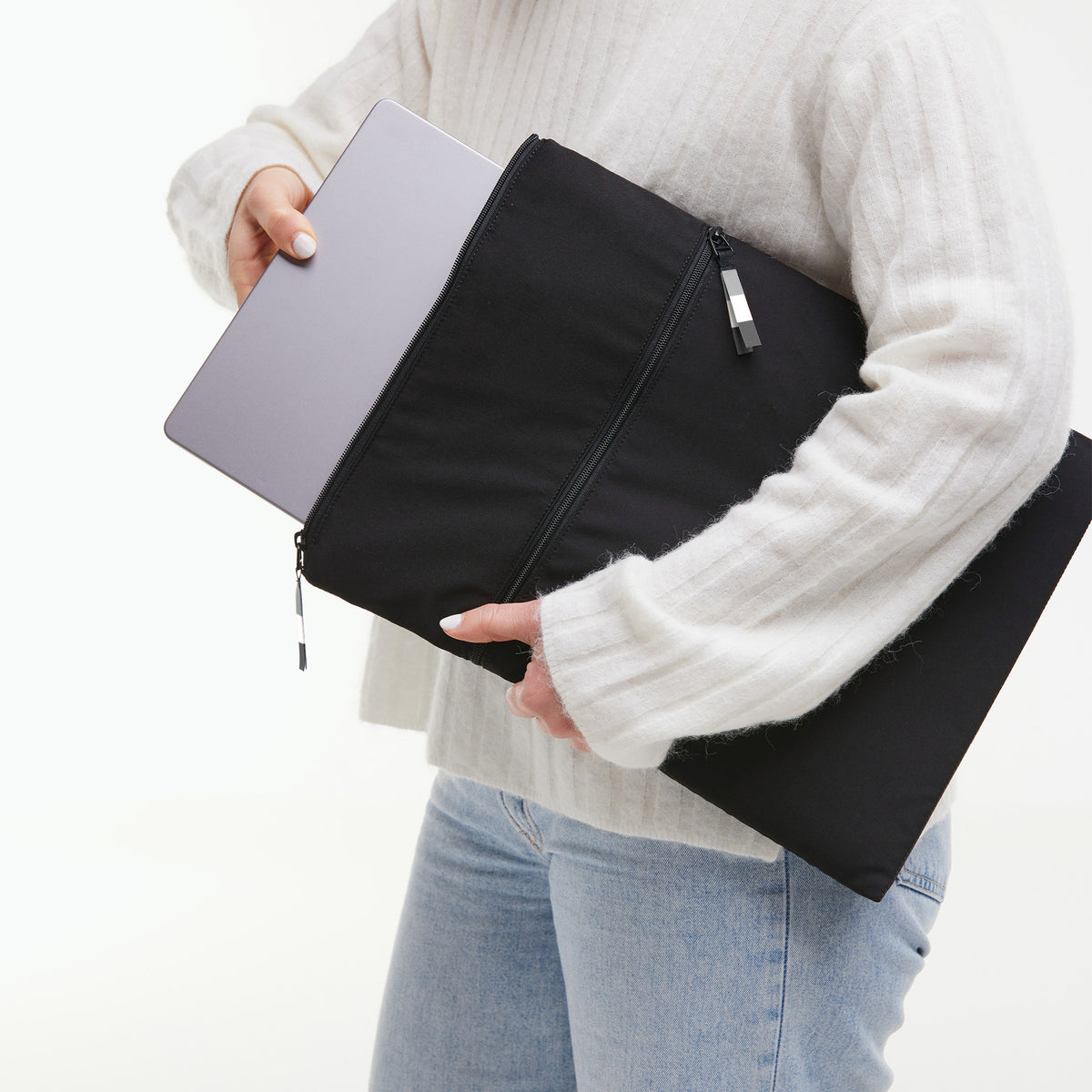 ROLLTOP Tasche in black (Schwarz) von einer Frau in der Hand gehalten.