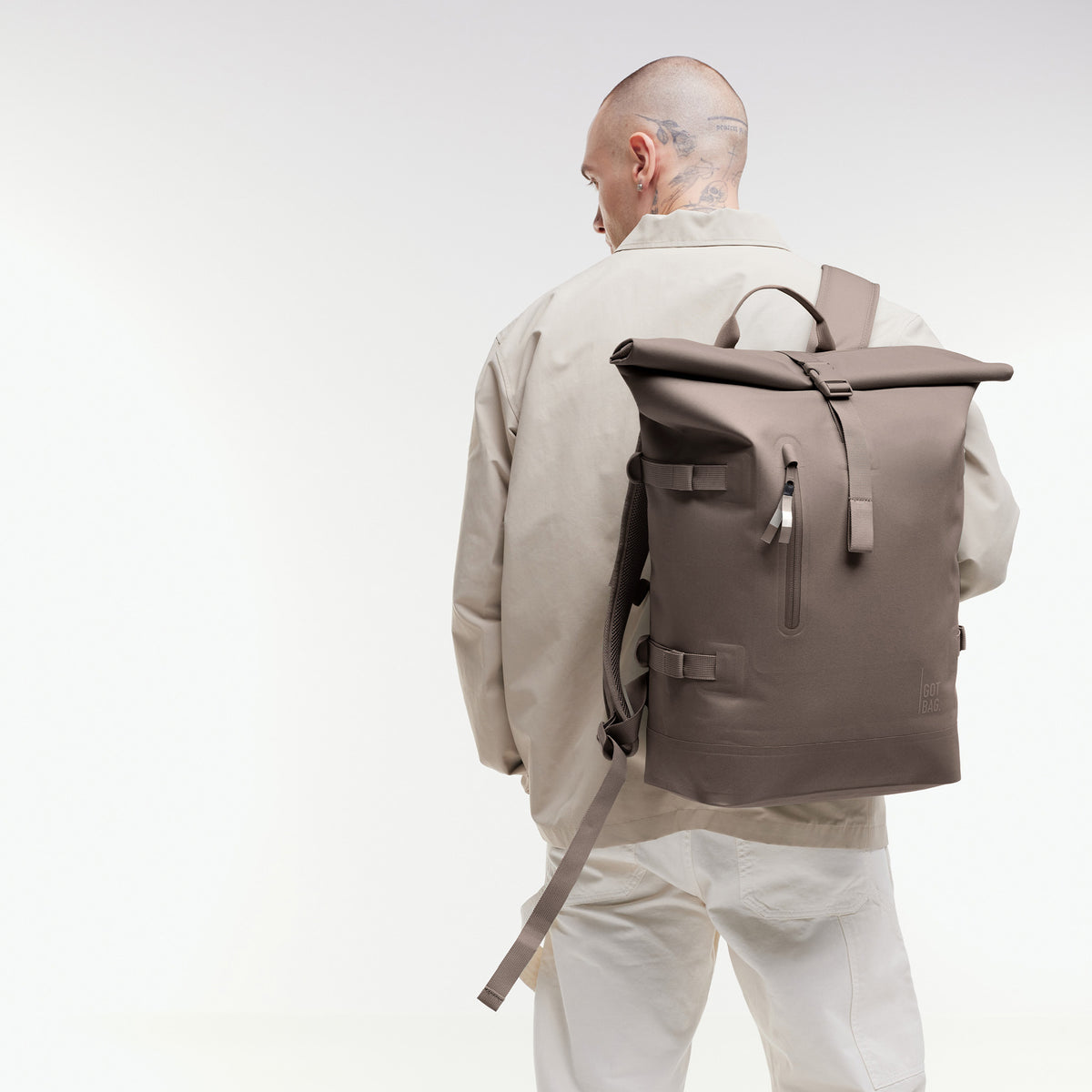 ROLLTOP 2.0 MONOCHROME EDITION Rucksack in oyster (klassisches Taupe-Braun) von einem Mann auf dem Rücken getragen.