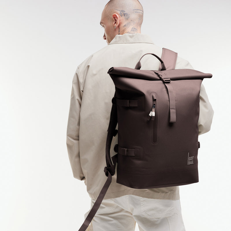 ROLLTOP 2.0 MONOCHROME EDITION Rucksack in tadpole (Schokobraun) von einem Mann als Rucksack auf dem Rücken getragen.