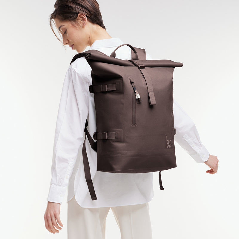 ROLLTOP 2.0 MONOCHROME EDITION Rucksack in tadpole (Schokobraun) von einer Frau als Rucksack auf dem Rücken getragen.