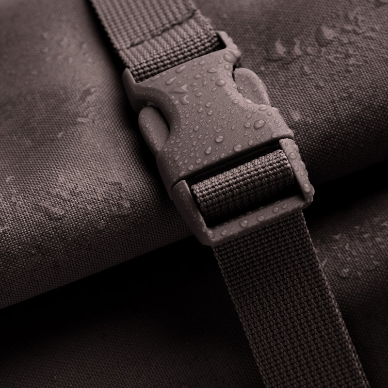 ROLLTOP Rucksack in tadpole (Schokobraun) als Detailaufnahme mit Wassertropfen auf Schnalle und Stoff.