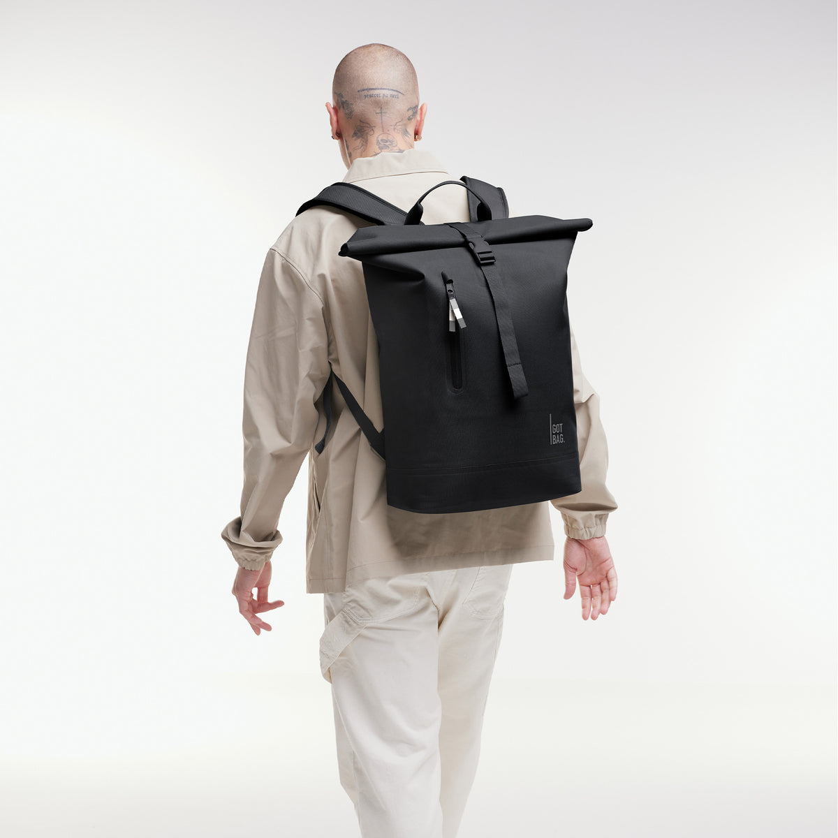 ROLLTOP LITE Rucksack in black (Schwarz) von einem Mann als Rucksack auf dem Rücken getragen.