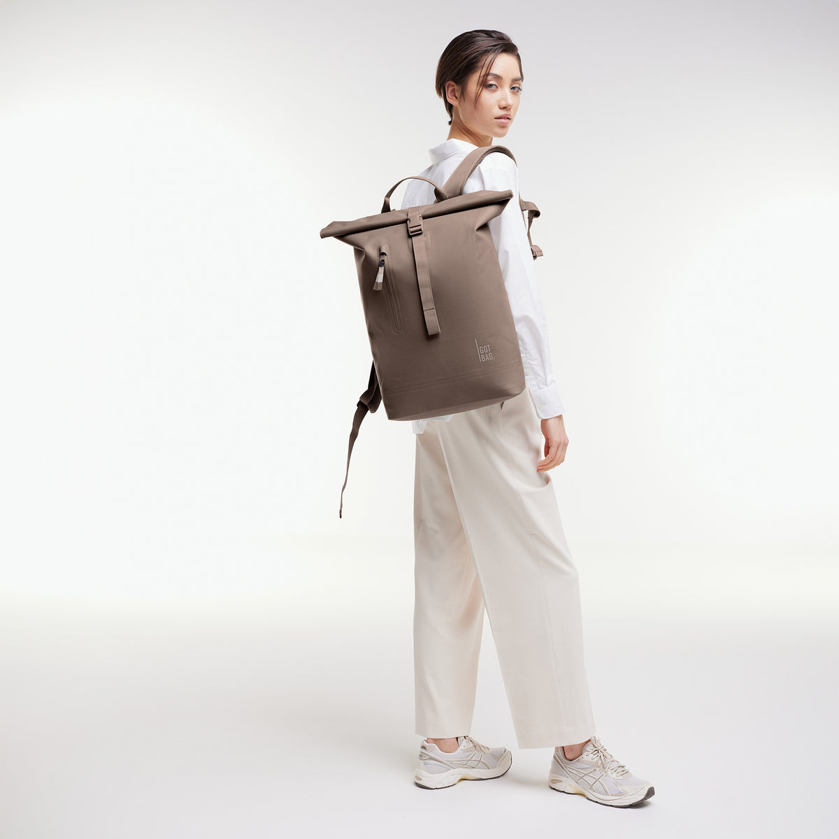 ROLLTOP LITE 2.0 Rucksack in oyster (klassisches Taupe-Braun) von einer Frau als Rucksack auf dem Rücken getragen.