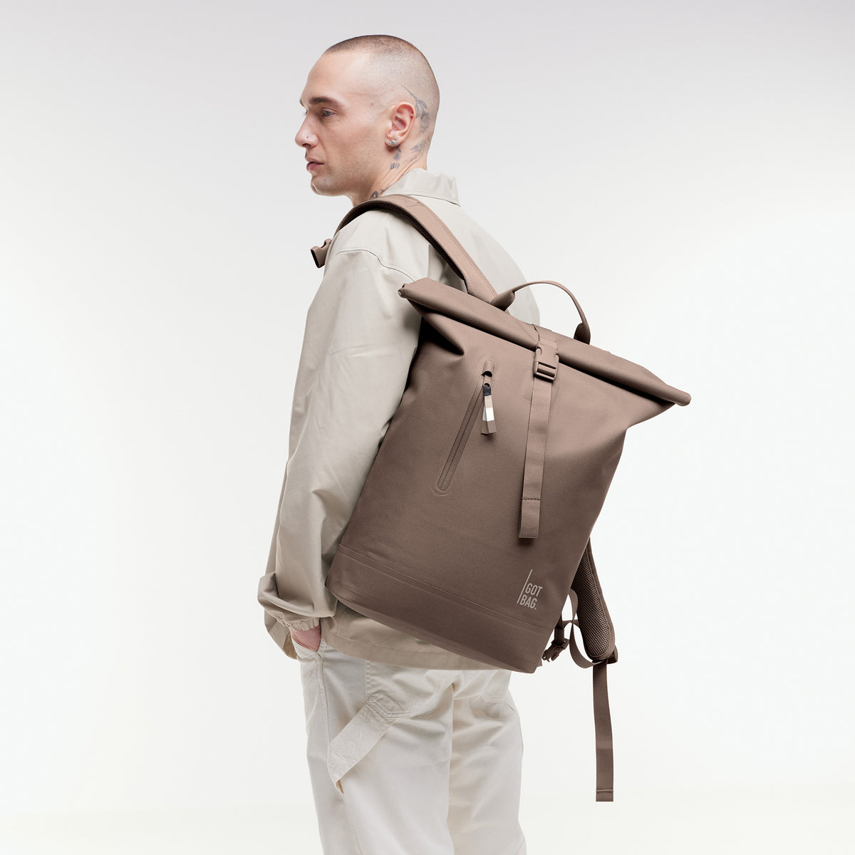 ROLLTOP LITE 2.0 Rucksack in oyster (klassisches Taupe-Braun) von einem Mann auf dem Rücken getragen.