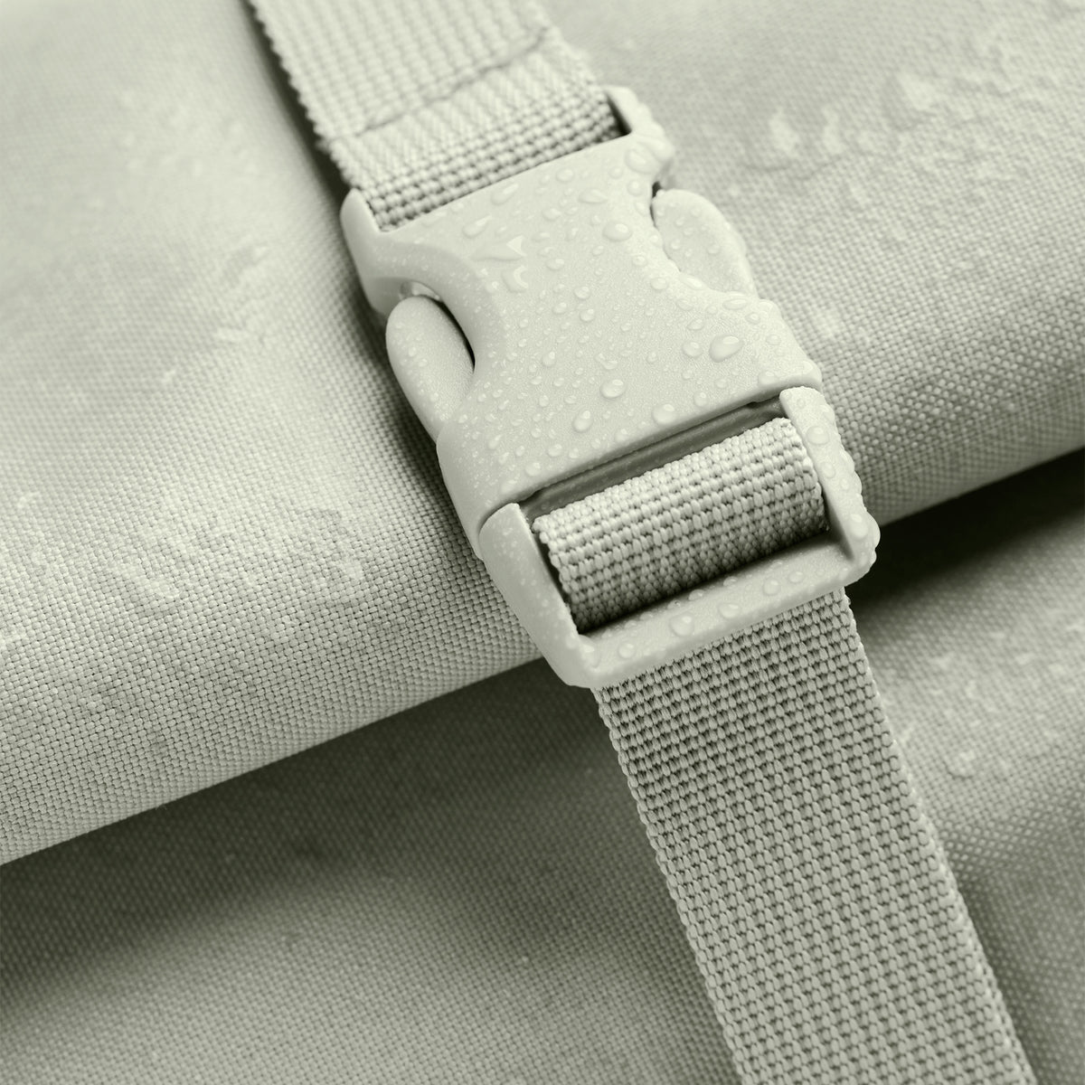 ROLLTOP LITE 2.0 MONOCHROME Rucksack in porpoise (helles Grau mit frischem grünen Unterton) mit Verschluss und Wassertropfen.