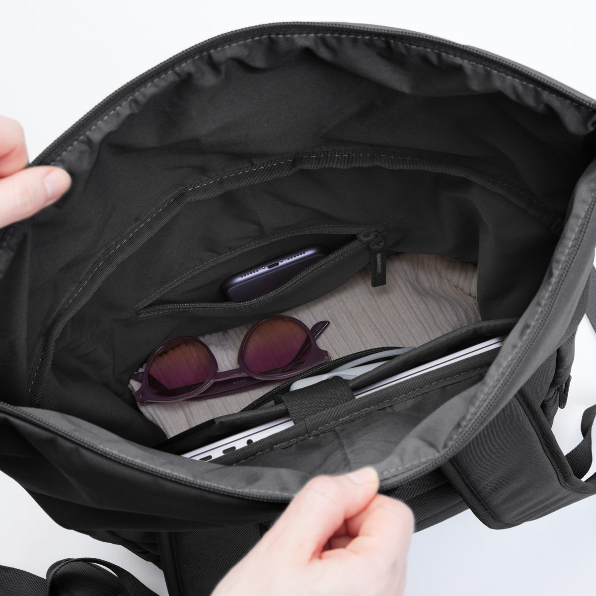 ROLLTOP EASY Rucksack in shark (Dunkelgrau), Blick in den geöffneten Innenraum mit Laptop, Handy und Sonnenbrille.