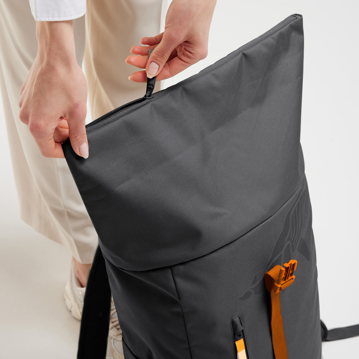 ROLLTOP EASY Rucksack in shark (Dunkelgrau) von einer Frau geöffnet.