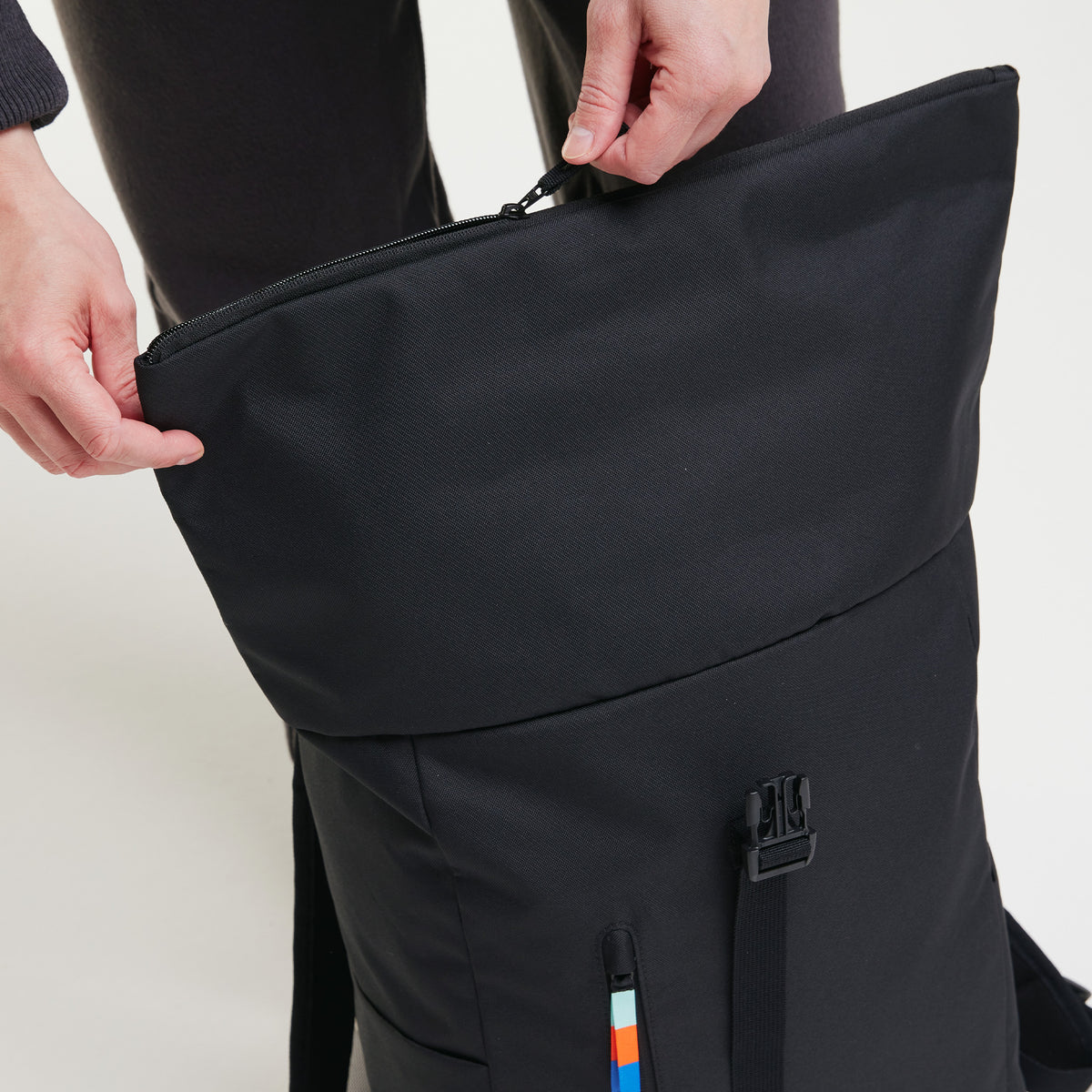 ROLLTOP EASY Rucksack in black (Schwarz), Hände öffnen den Rucksack.
