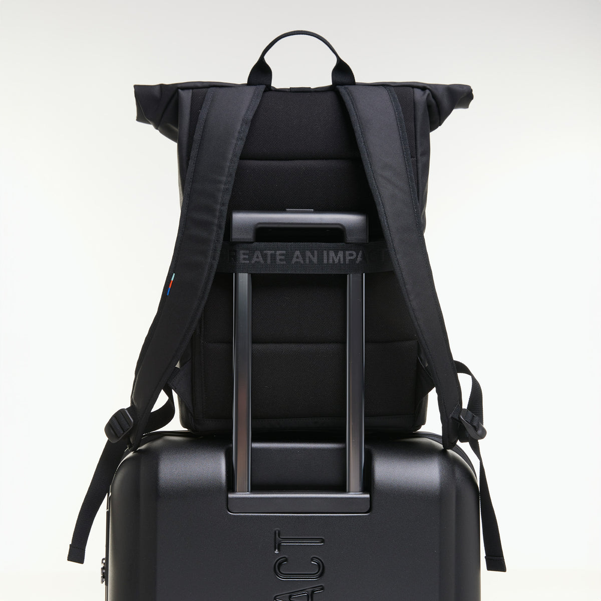 ROLLTOP EASY Rucksack in black (Schwarz) mit Trolley-Aufsteckfunktion auf einer Koffergriffstange.