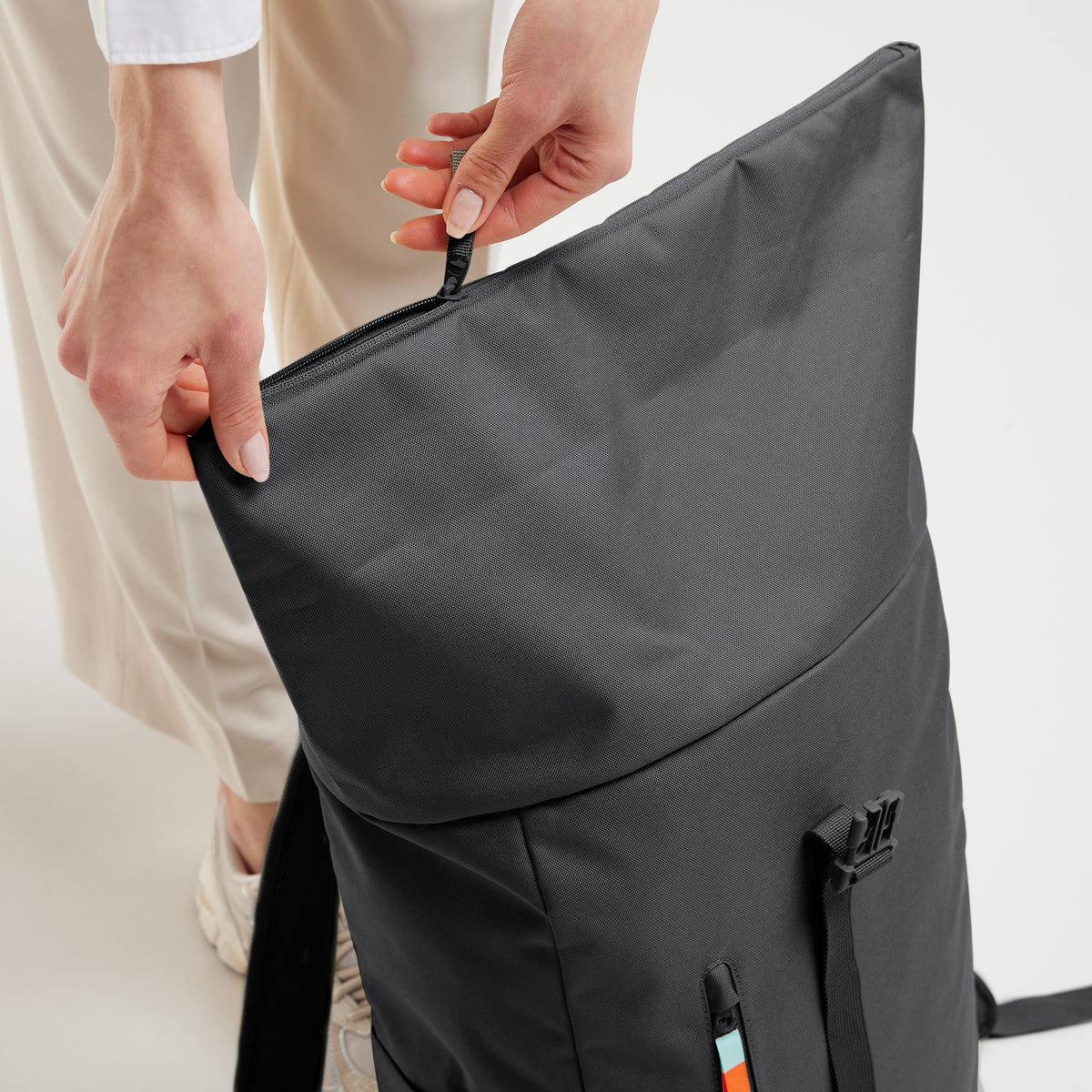 ROLLTOP EASY Rucksack in shark (Dunkelgrau), von einer Frau geöffnet.