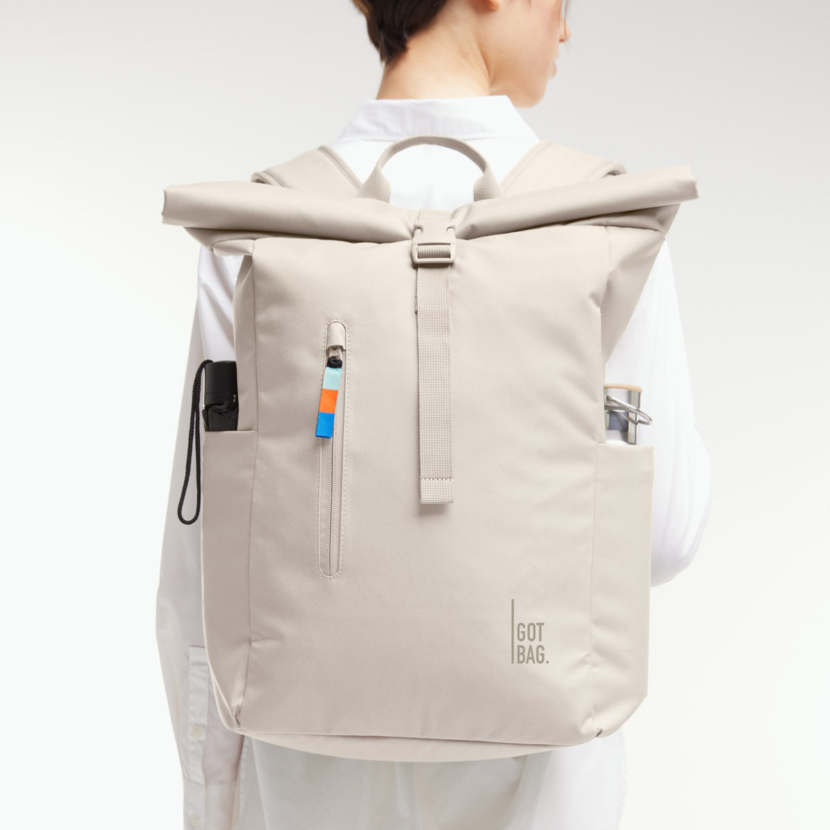 ROLLTOP EASY Rucksack in soft shell (warmes Cremeweiß) von einer Frau als Rucksack auf dem Rücken getragen.