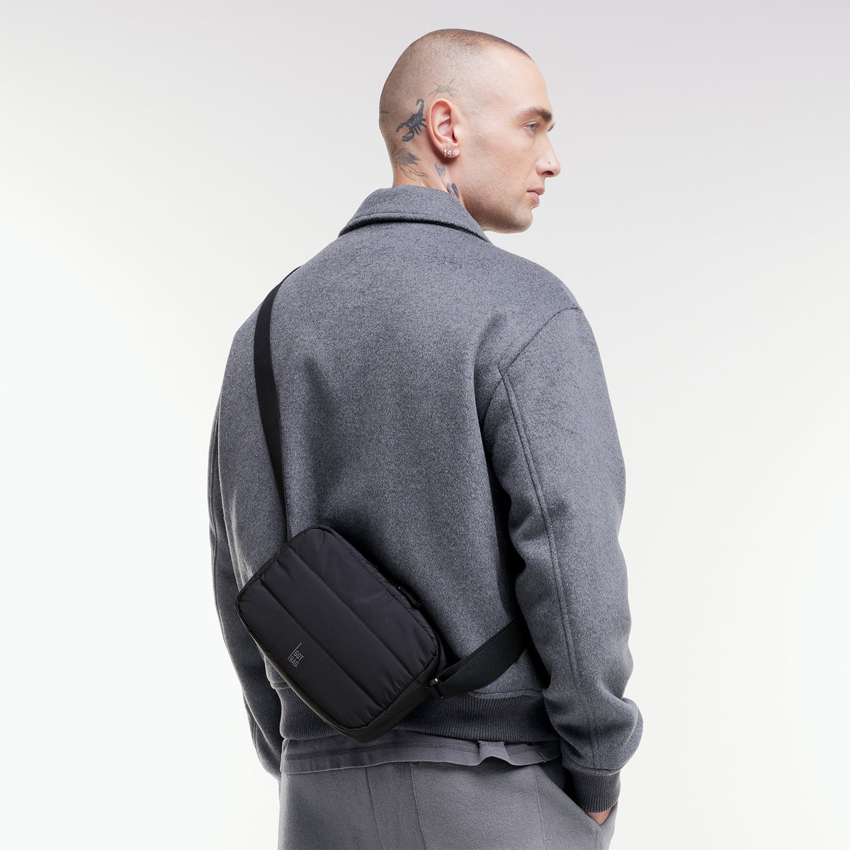 PUFFER CROSSBODY BAG Tasche in black (Schwarz) von einem Mann crossbody getragen.