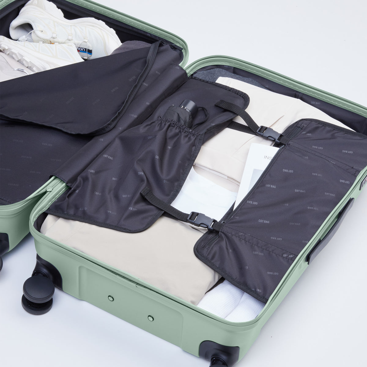 RE SHELL CHECKED Koffer in reef (intensives Salbeigrün) geöffnet mit gepacktem Inhalt von oben.