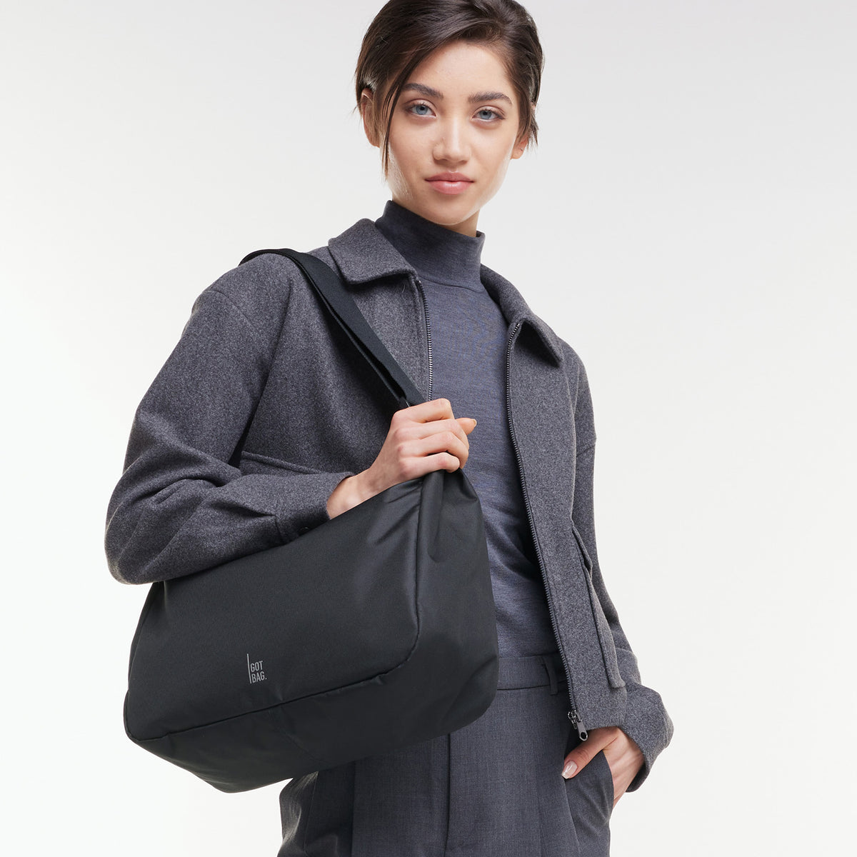 SQUARE BAG LARGE Tasche in black (Schwarz) von einer Frau über der Schulter getragen.