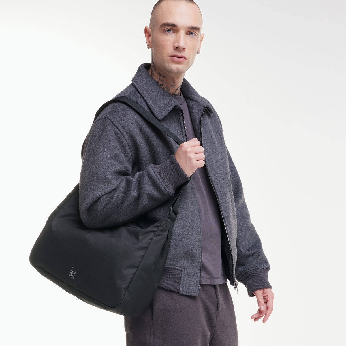 SQUARE BAG LARGE Tasche in black (Schwarz) von einem Mann über der Schulter getragen.