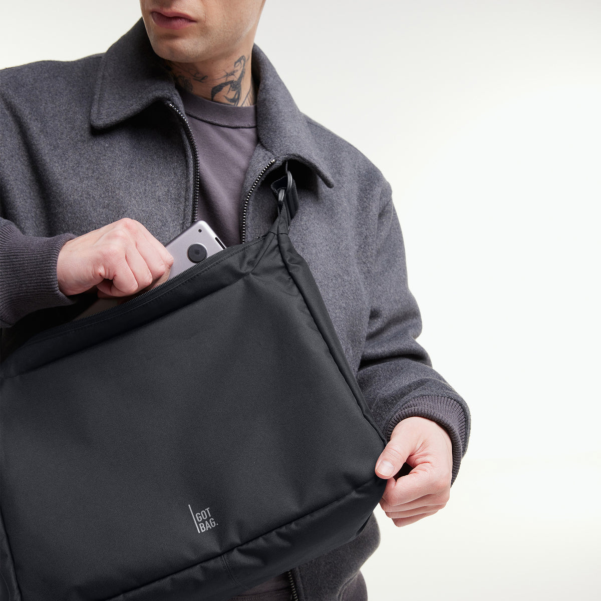 SQUARE BAG LARGE Tasche in black (Schwarz) von einem Mann crossbody getragen.