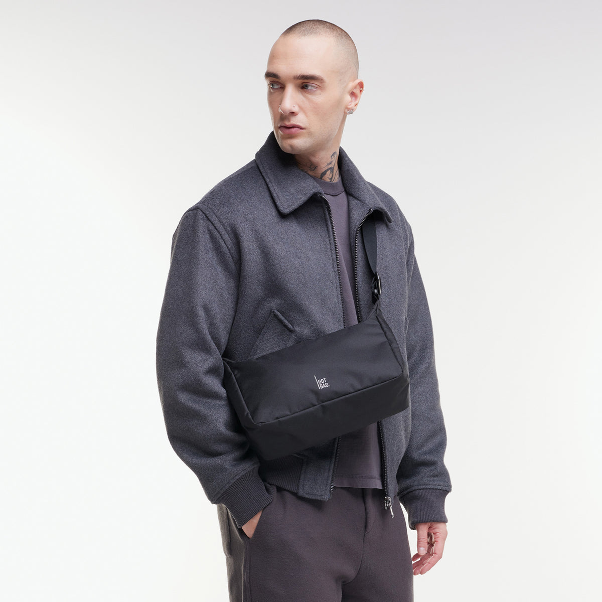 SQUARE BAG SMALL Tasche in black (Schwarz) von einem Mann crossbody getragen.