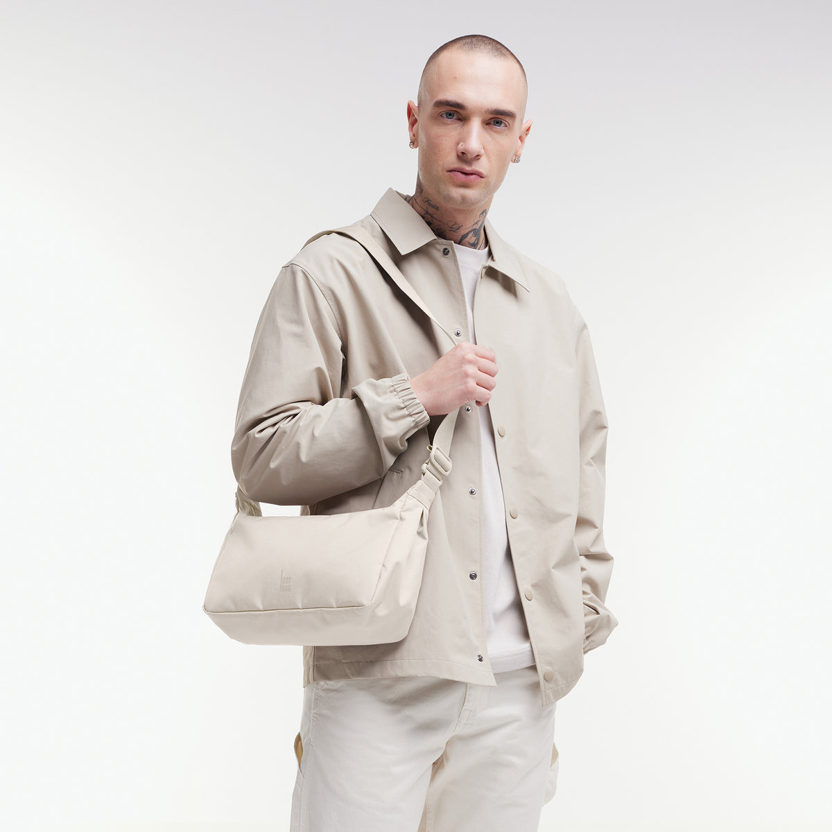 SQUARE BAG SMALL Tasche in soft shell (warmes Cremeweiß) von einem Mann crossbody getragen.