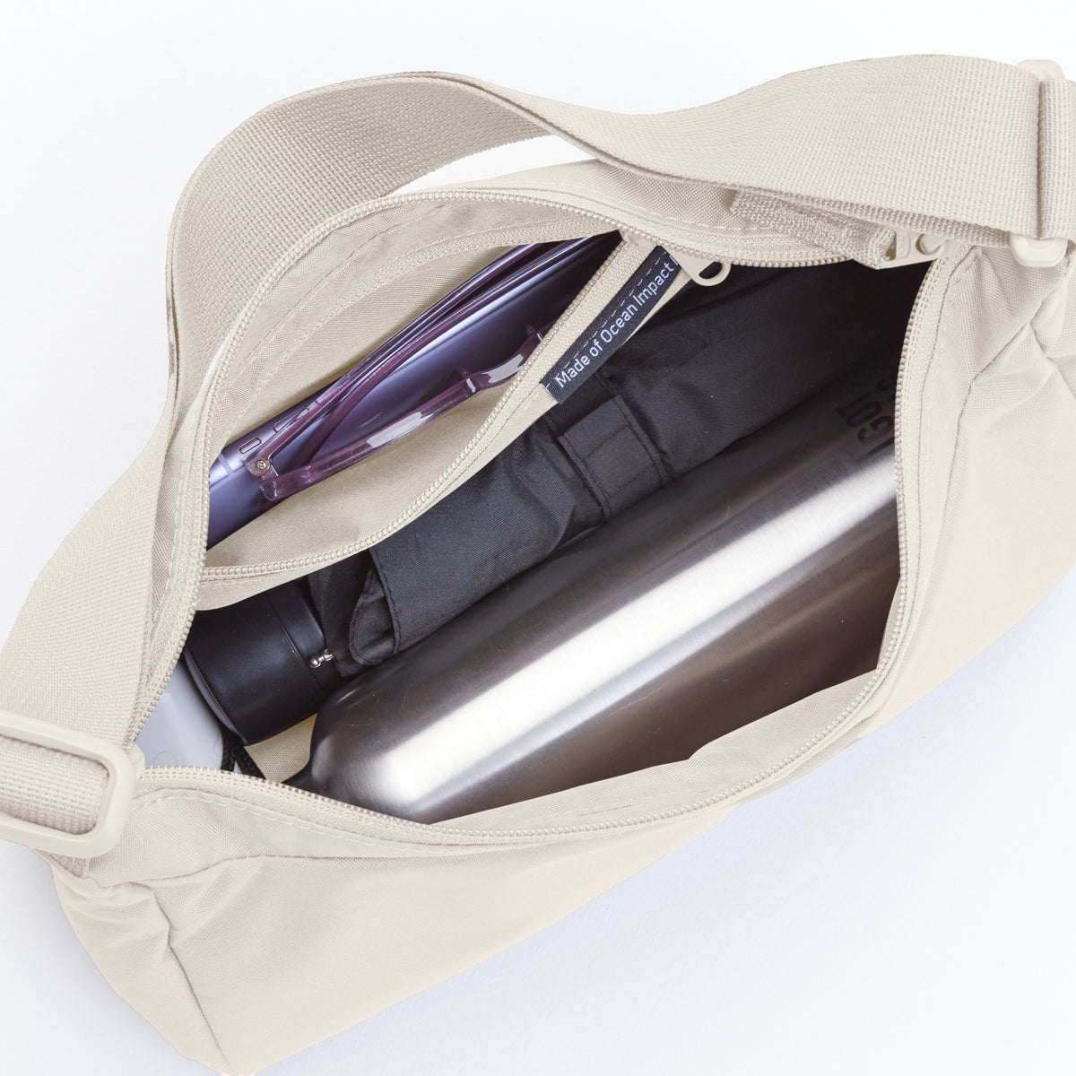 SQUARE BAG SMALL Tasche in soft shell (warmes Cremeweiß), von oben geöffnet mit Inhalt.