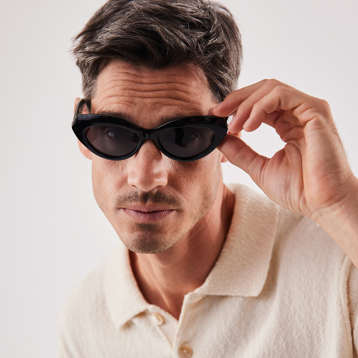 RE SHADES NO.01 RE:SHADE in black (Schwarz) von einem Mann getragen, der sie mit der Hand hält.