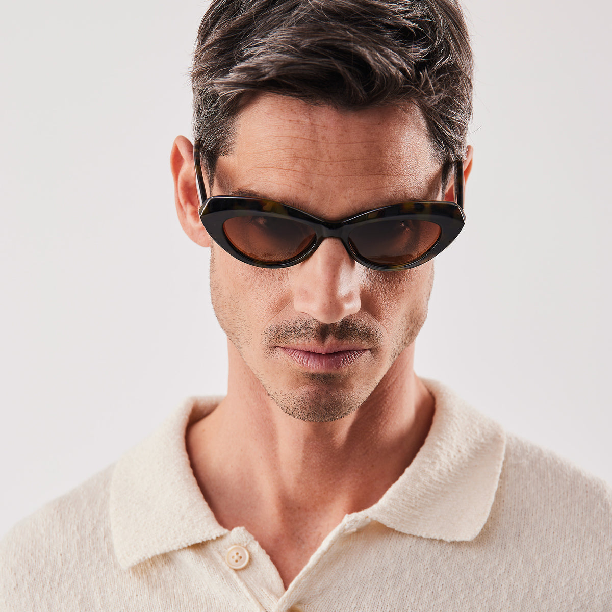 RE SHADES NO 01 RE:SHADE in tortoise von einem Mann getragen, der nach unten blickt.