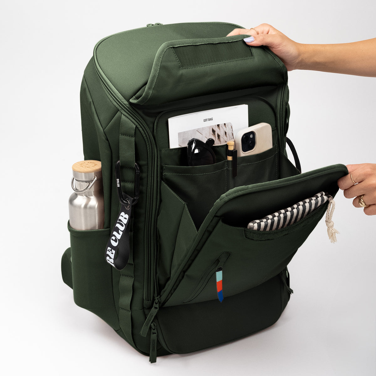 PRO PACK TRAVEL Rucksack in algae (Dunkelgrün mit Graustich), eine Frau öffnet ihn und greift hinein.