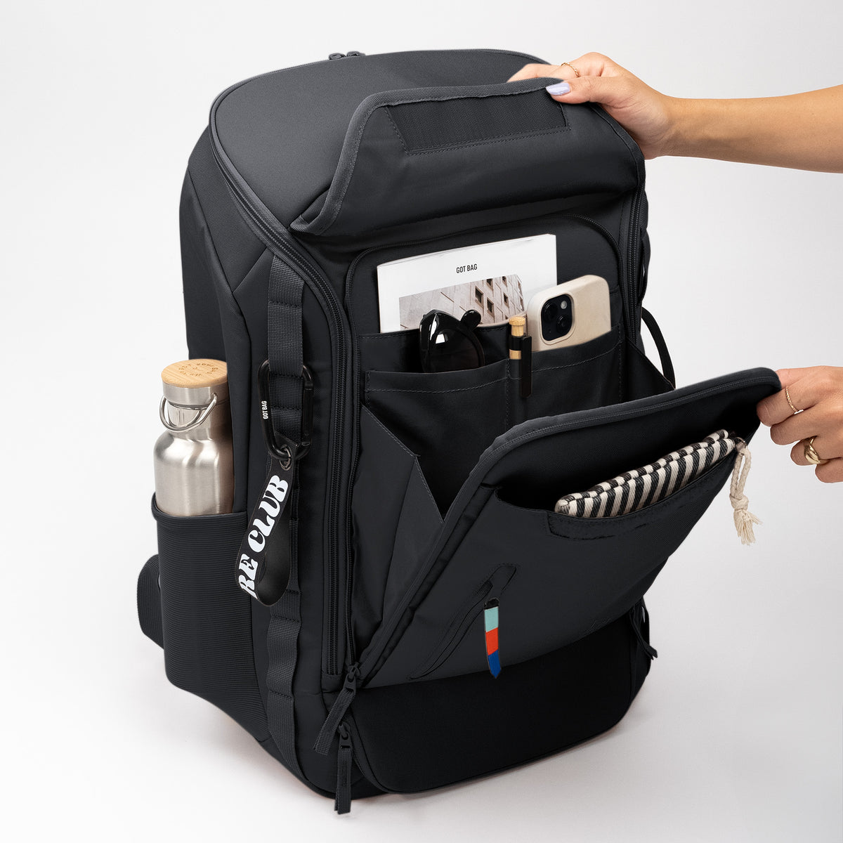 PRO PACK TRAVEL Rucksack in black (Schwarz) von einer Frau geöffnet, die das Innere zeigt.
