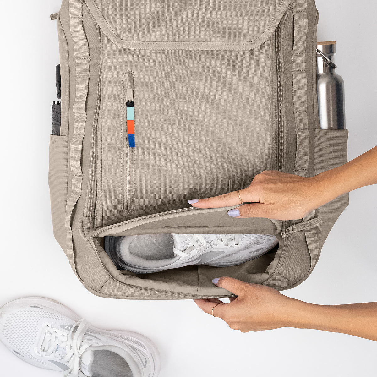 PRO PACK TRAVEL Rucksack in scallop (helles Beige), eine Frau öffnet ein Fach für einen Sportschuh.