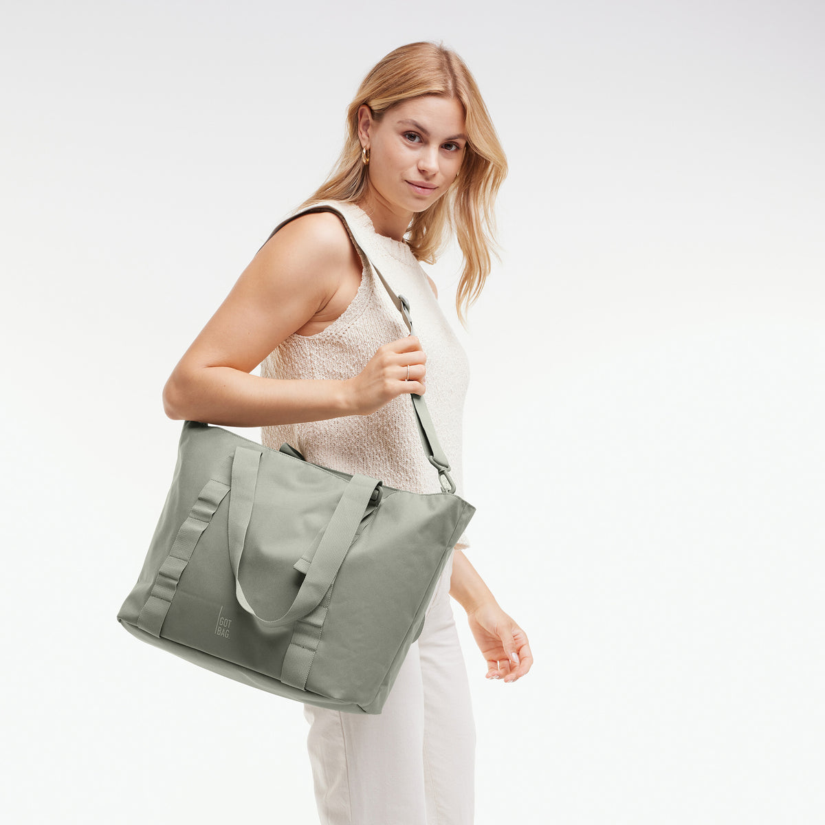 TOTE BAG Tasche in bass (Salbeigrün) von einer Frau über der Schulter getragen.