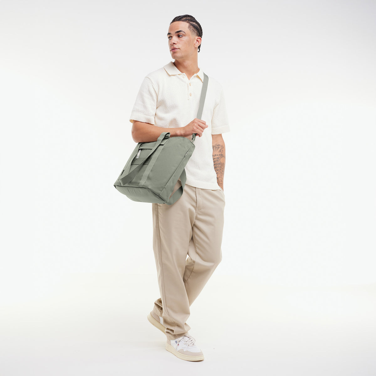 TOTE BAG Tasche in bass (Salbeigrün) von einem Mann über der Schulter getragen.