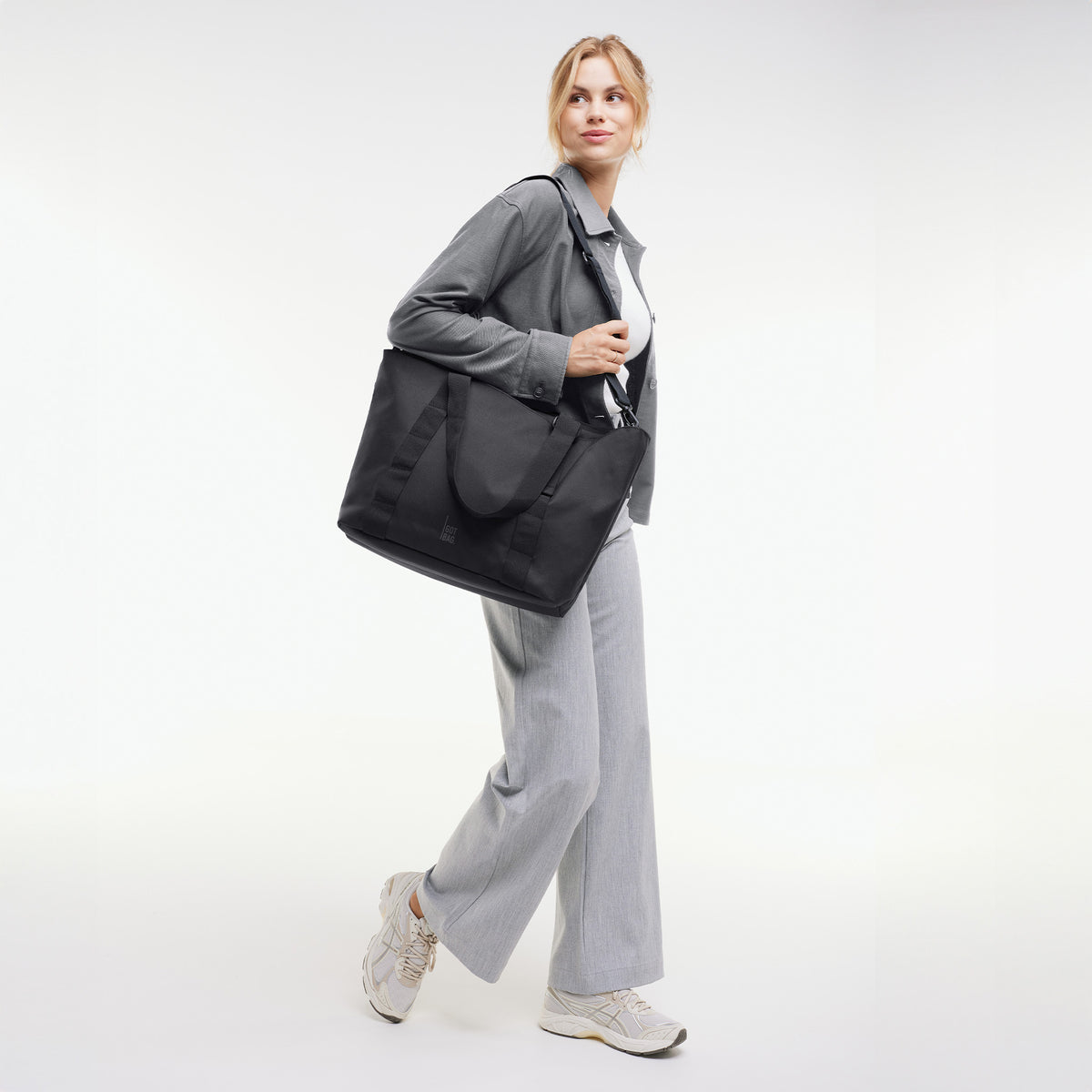 TOTE BAG Tasche in black (Schwarz) von einer Frau über der Schulter getragen.