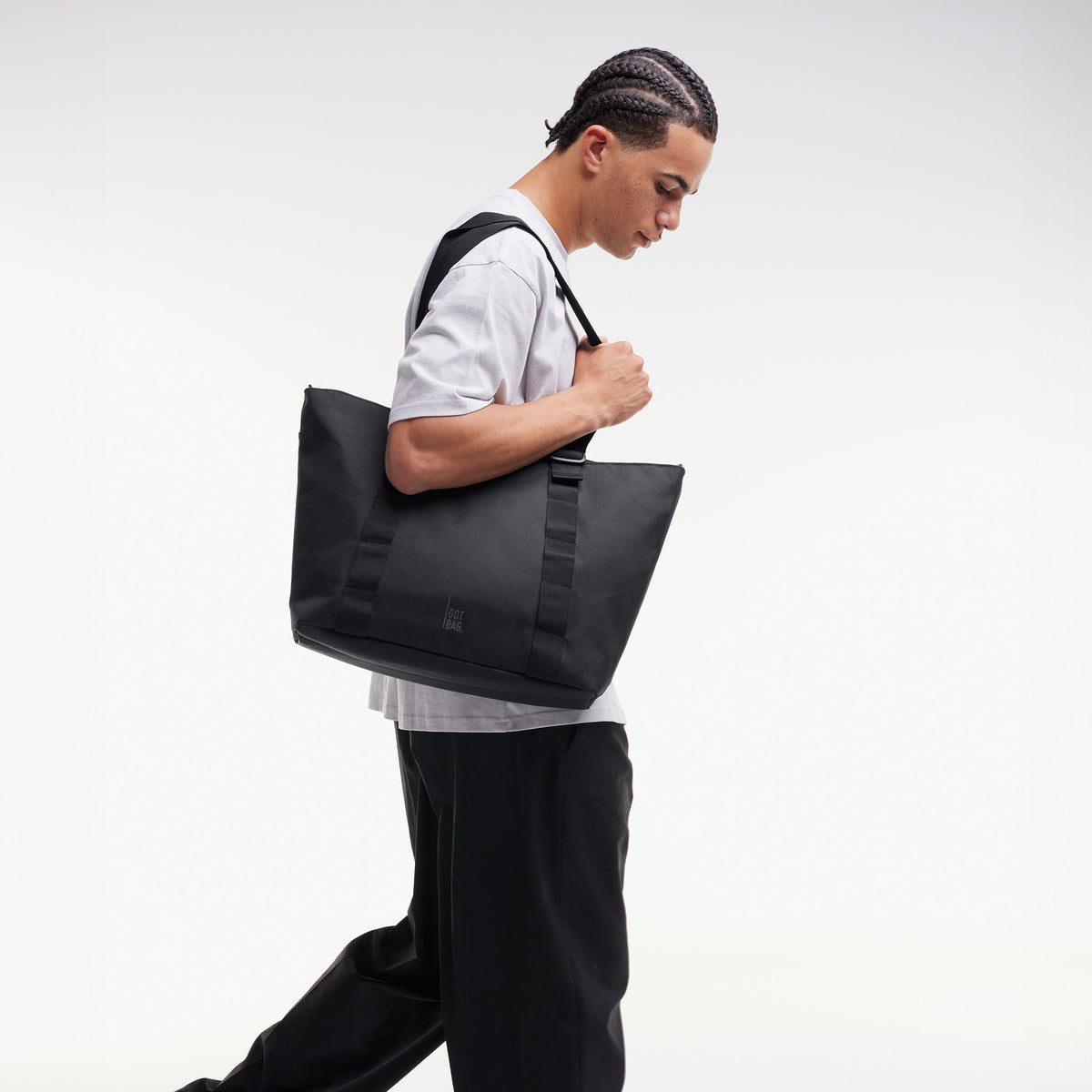 TOTE BAG Tasche in black (Schwarz) von einem Mann über der Schulter getragen.