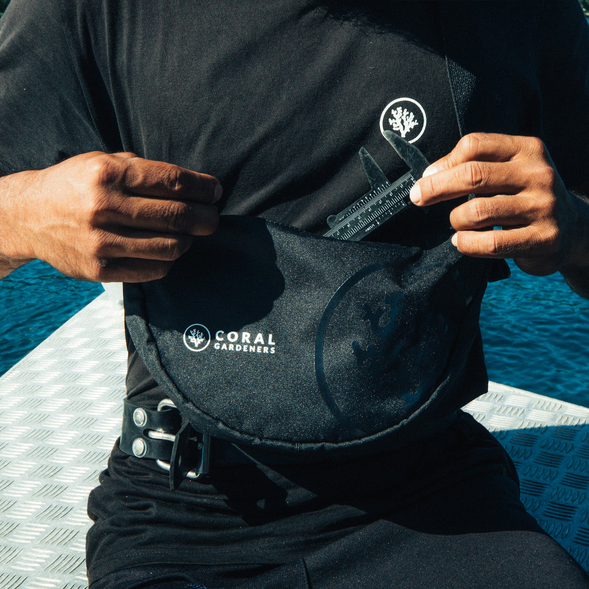 MOON BAG SMALL Tasche in black (Schwarz) von einem Mann crossbody getragen.