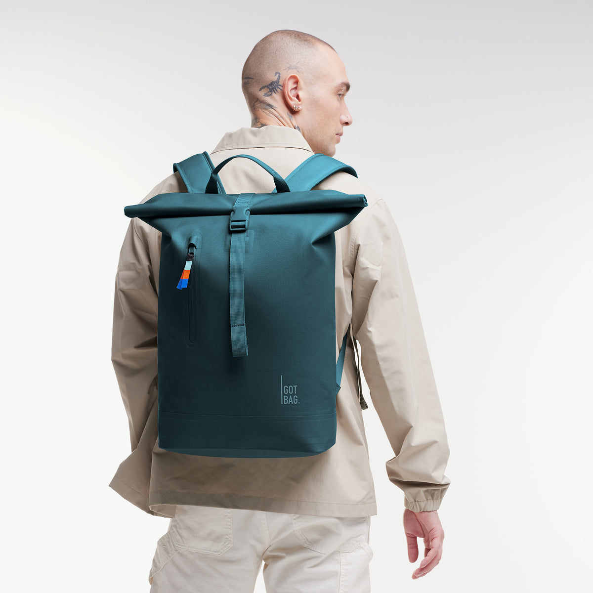 ROLLTOP LITE Rucksack in cliff (dunkles Petrol) von einem Mann auf dem Rücken getragen.