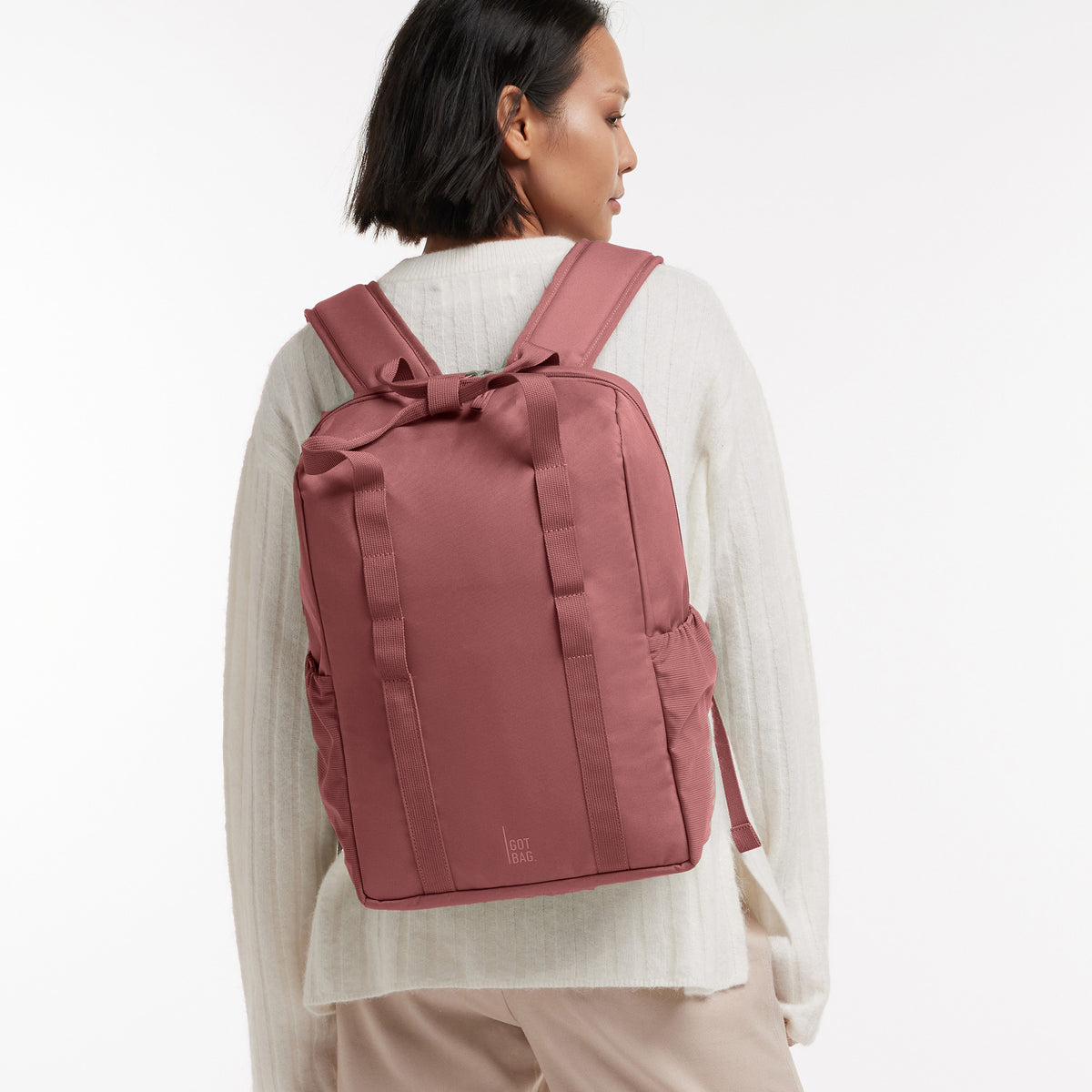 DAYPACK LOOP Rucksack in lionfish (dunkles Rosa mit Rotstich) von einer Frau als Rucksack auf dem Rücken getragen.