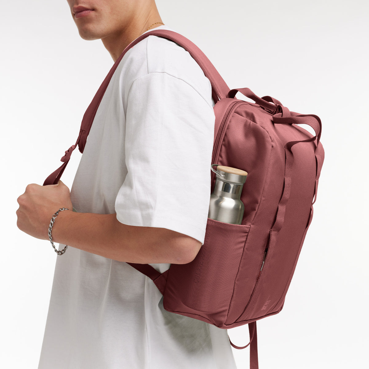 DAYPACK LOOP Rucksack in lionfish (dunkles Rosa mit Rotstich) von einem Mann auf dem Rücken getragen.