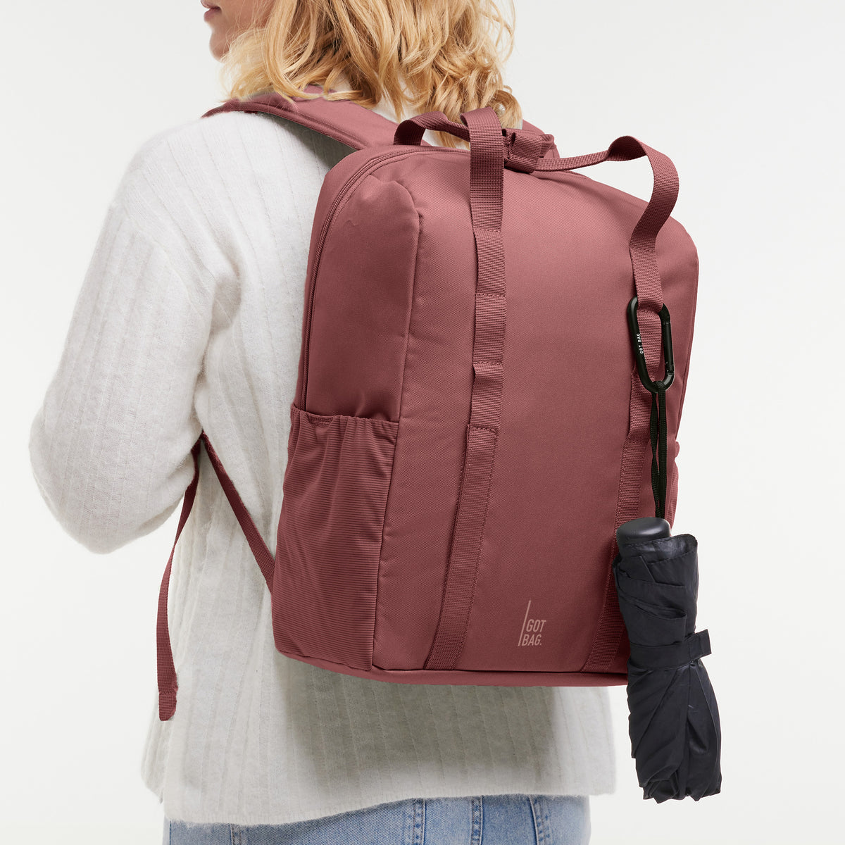 DAYPACK LOOP Rucksack in lionfish (dunkles Rosa mit Rotstich) von einer Frau auf dem Rücken getragen.