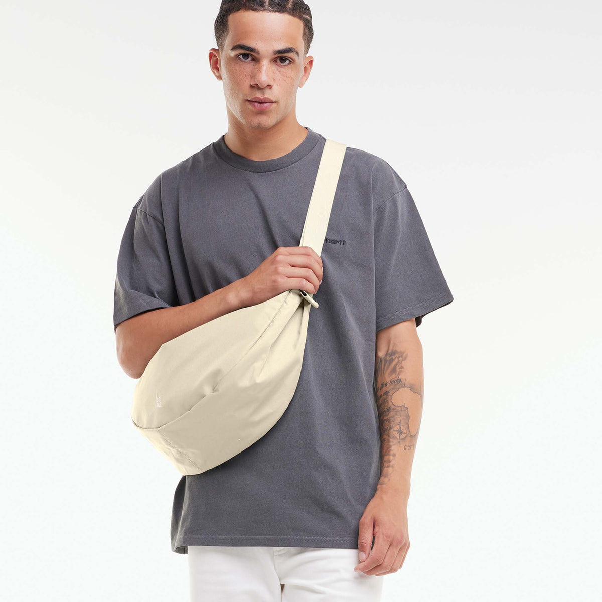 MOON BAG LARGE Tasche in salt (warmes Cremeweiß) von einem Mann crossbody getragen.