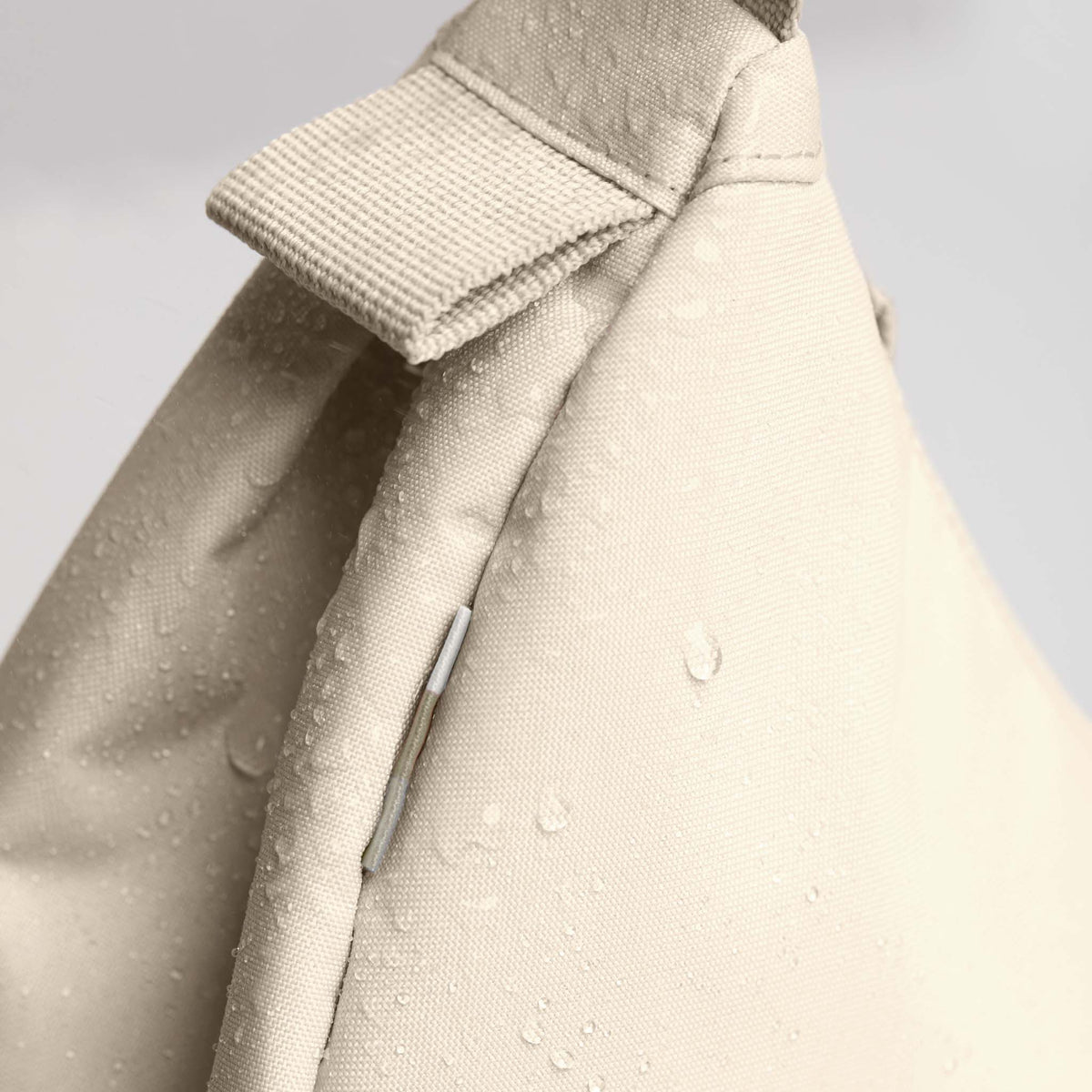 MOON BAG LARGE Tasche in salt (warmes Cremeweiß), Detailaufnahme mit Wassertropfen auf dem Stoff.