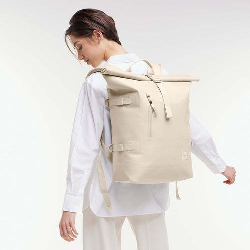 ROLLTOP 2.0 MONOCHROME EDITION Rucksack in salt (warmes Cremeweiß) von einer Frau als Rucksack auf dem Rücken getragen.