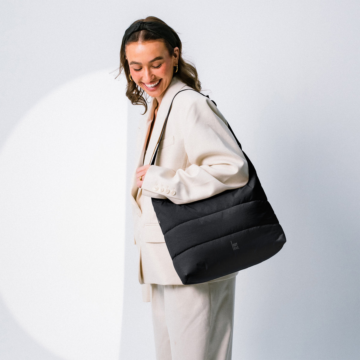 PUFFER SQUARE BAG Tasche in black (Schwarz) von einer Frau über der Schulter getragen.