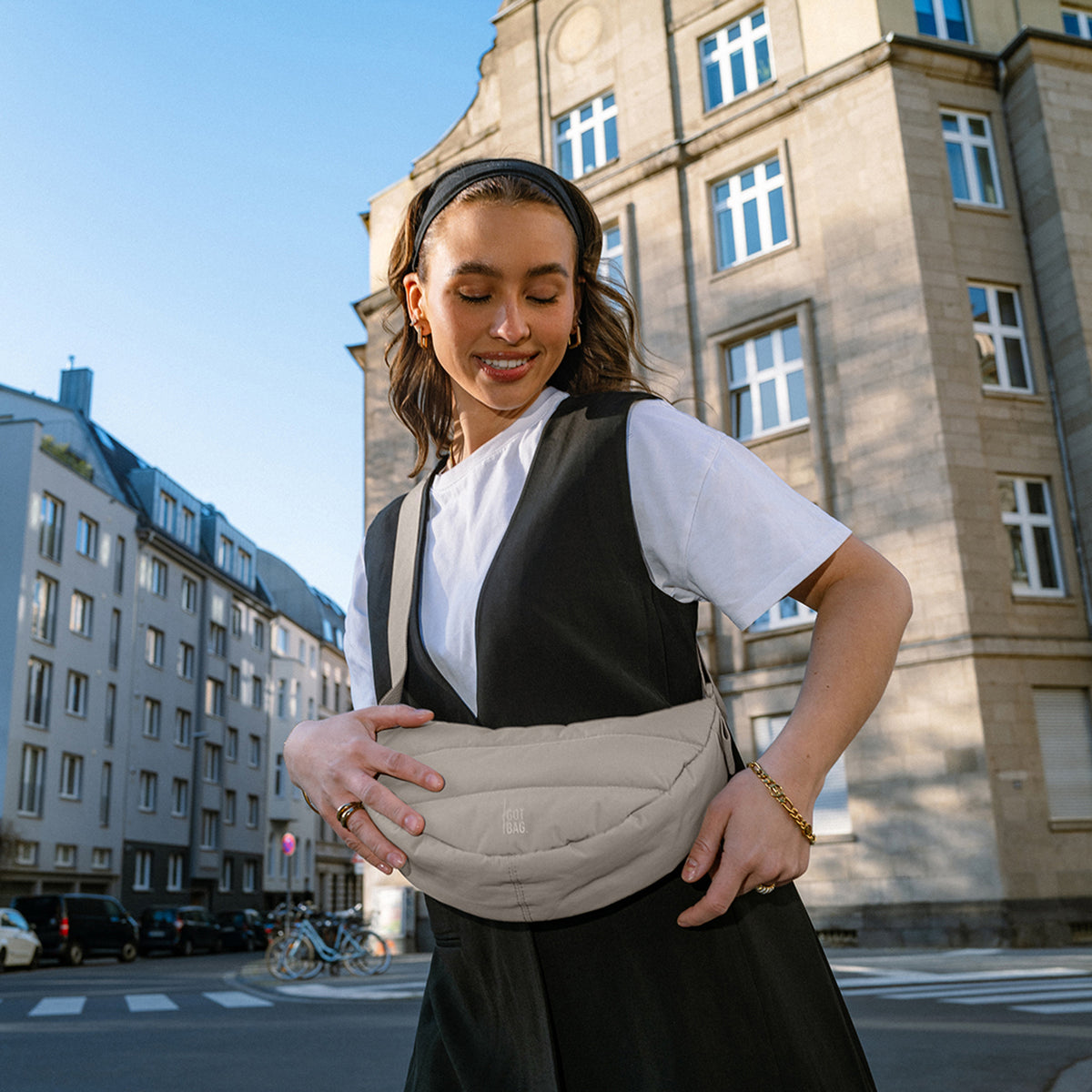 PUFFER MOON BAG SMALL Tasche in scallop (helles Beige) von einer Frau crossbody getragen.