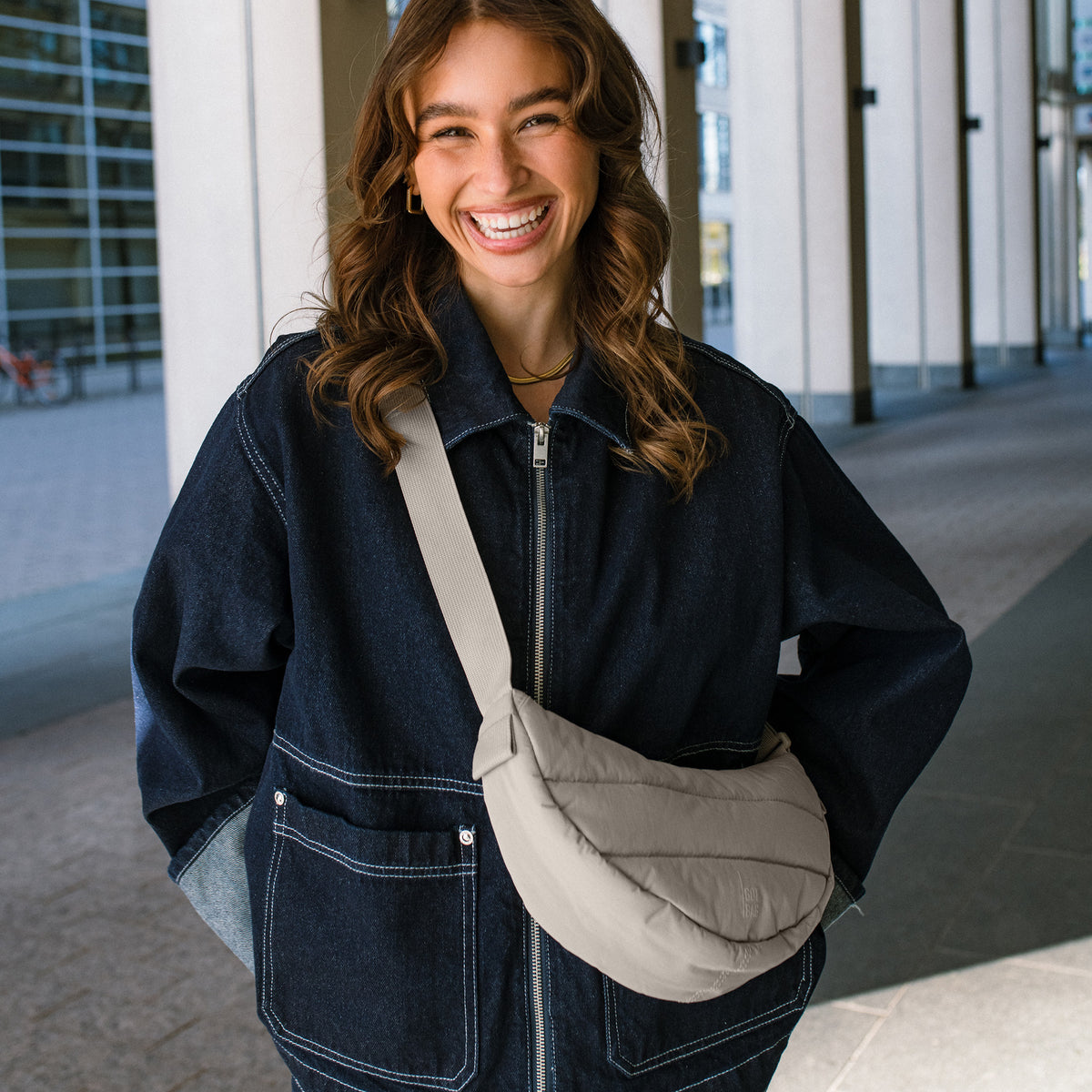PUFFER MOON BAG SMALL Tasche in scallop (helles Beige) von einer Frau crossbody getragen.